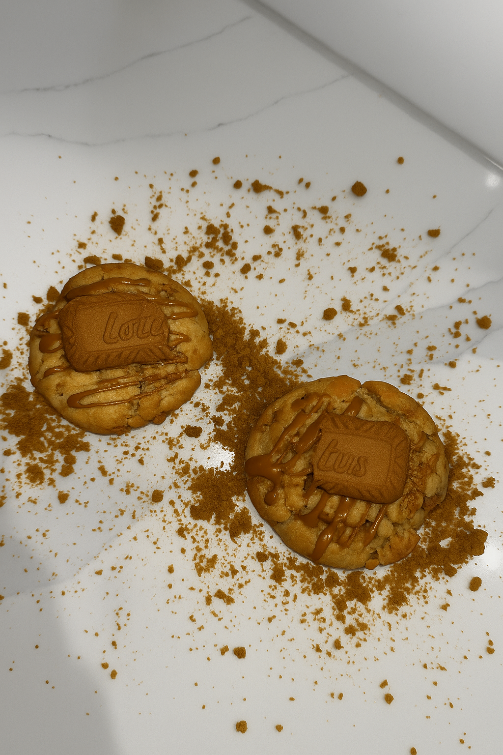 Biscoff cookies drizzled with caramel on a marble surface